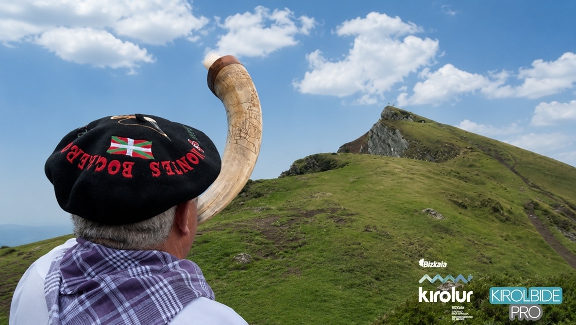 A person sounding the call to the assemblies in Gernika with a horn, on the summit of a mountain